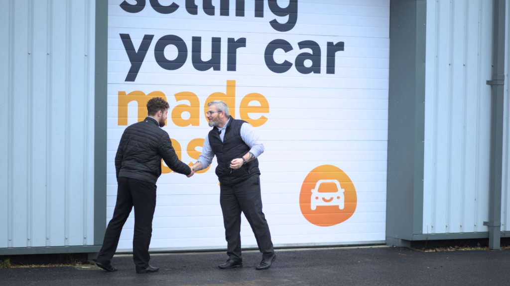 men shaking hands exchanging the keys to a car